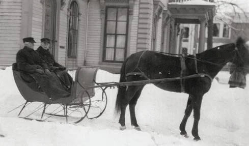 People in horse-drawn sled on a snowy day