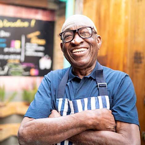 Man in apron smiling.