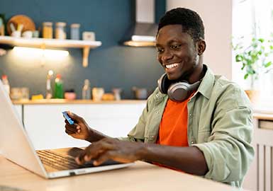 Guy with credit card using laptop.