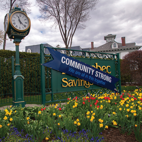 Kennebec Savings Bank sign with tulips and sash reading community strong