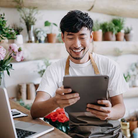 Man in flower shop using tablet.