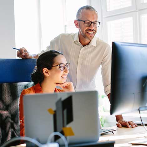 Man and woman coworkers looking at computer.